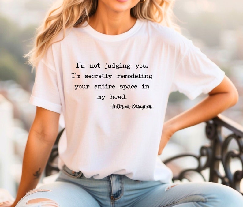 K&ouml;nnte beinhalten: Ein wei&szlig;es T-Shirt mit einem schwarzen Text-Motiv, auf dem steht: "Ich verurteile dich nicht. Ich renoviere heimlich deinen gesamten Raum in meinem Kopf. -Innenarchitekt"