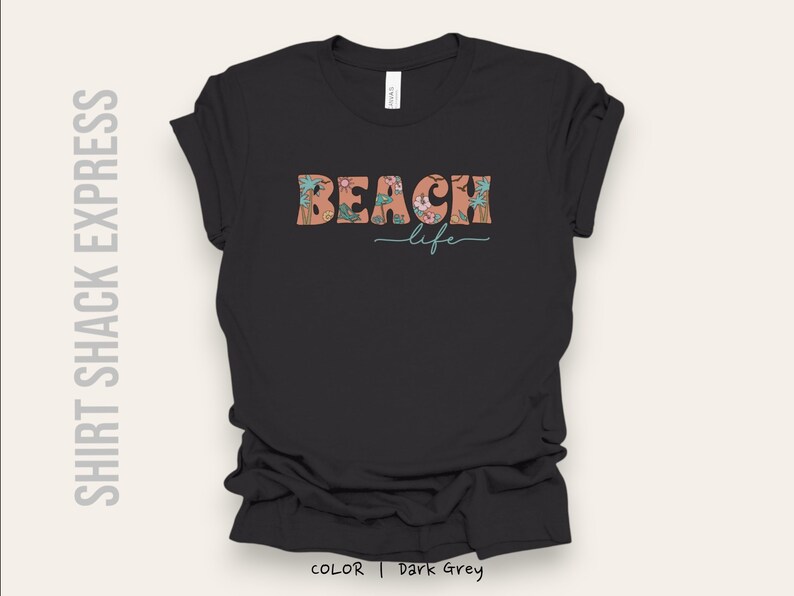 May include: Dark grey t-shirt with a floral design and the text "Beach life" in a retro font.
