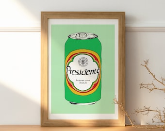 Op de afbeelding: Een ingelijst afdruk van een groene blik Presidente-bier. De blik heeft een geel en rood etiket met het woord "Presidente" in een witte cirkel.