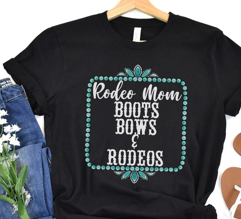May include: Black t-shirt with a turquoise and white design that says "Rodeo Mom Boots Bows & Rodeos".