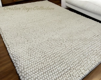 May include: Off-white, textured area rug with a dense, nubby surface. The rug is rectangular and appears to be made of wool or a similar material. The words "Creative Rugs Collection" are visible in the top left corner.