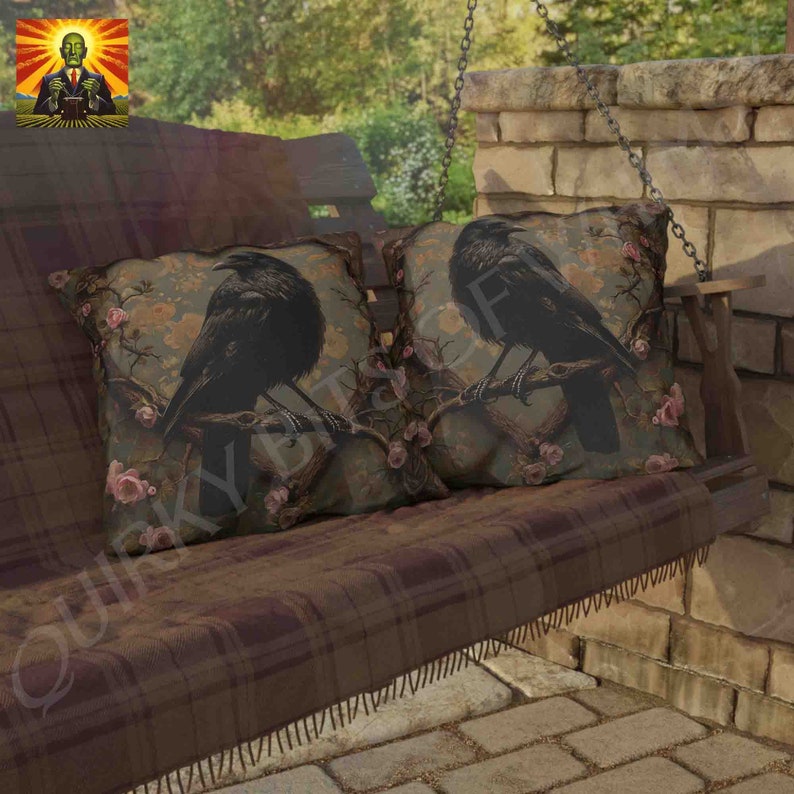 May include: Two throw pillows with a brown and green floral pattern and black crows perched on branches. The pillows are on a brown plaid swing bench.