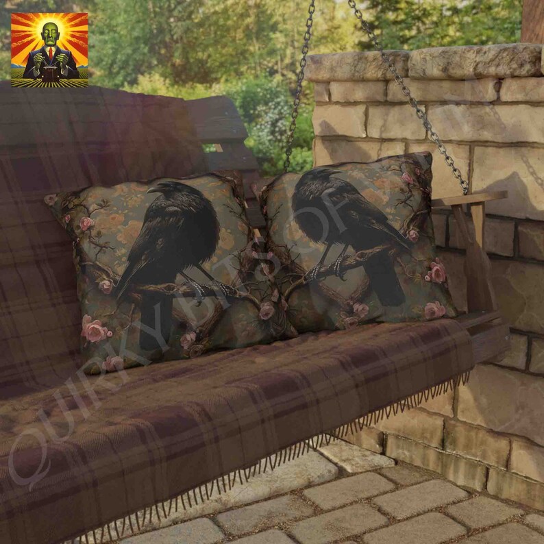 May include: Two throw pillows with a dark brown background and a black crow perched on a branch with pink flowers. The pillows are on a brown plaid swing with a wooden frame.