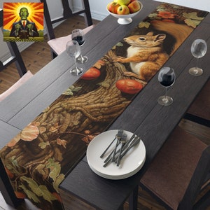 May include: A brown and yellow table runner with a squirrel and autumn leaves. The runner is on a dark wood table with white plates and silverware.