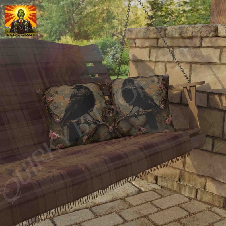 May include: Two black crow throw pillows with a floral design on a brown plaid swing. The pillows are on a wooden swing with a brown plaid cushion.