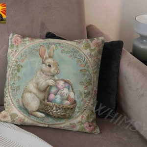May include: A decorative throw pillow with a vintage illustration of a white rabbit holding a basket of colorful Easter eggs. The background is a blue and green floral pattern.