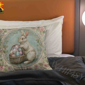 May include: A decorative pillow featuring a white rabbit holding a basket of colorful Easter eggs. The pillow has a floral design with a blue and green background.