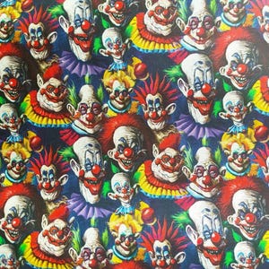 Könnte beinhalten: Ein sich wiederholendes Muster von Clown-Gesichtern mit roten Nasen, weißen Gesichtern und bunten Haaren und Kragen. Die Clowns haben verschiedene Ausdrücke, einige lächeln und andere haben einen finsteren Blick. Der Hintergrund ist dunkelblau.