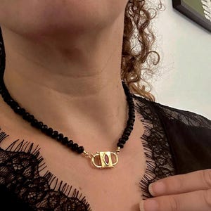 Elegant necklace made of black faceted stones with pendant and red zirconium stone