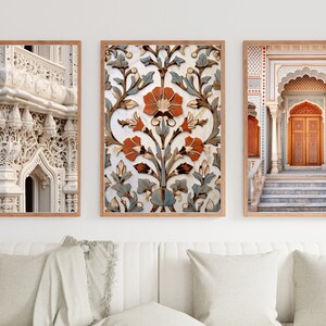 May include: Three framed prints depicting intricate architectural details from a mosque. The first print shows a close-up of a white, intricately carved archway. The second print features a floral pattern in shades of blue, white, and orange. The third print shows a doorway with a carved wooden door and a set of steps leading up to it.
