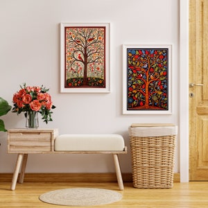 May include: Two framed art prints of colorful tree of life designs with birds and flowers. The prints are hanging on a white wall above a wooden bench with a wicker basket.