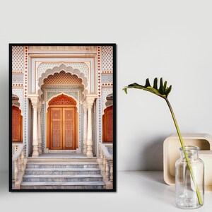 May include: A framed photograph of a grand, ornate doorway with intricate tile work and a wooden door. The doorway is framed by a series of arches and columns, and the steps leading up to it are made of marble.