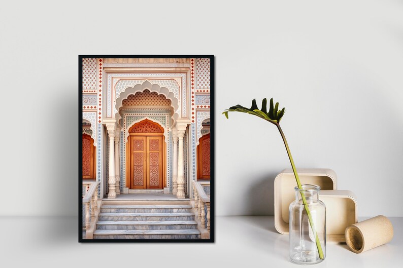 May include: A framed photograph of a grand, ornate doorway with intricate tile work and a wooden door. The doorway is framed by a series of arches and columns, and the steps leading up to it are made of marble.