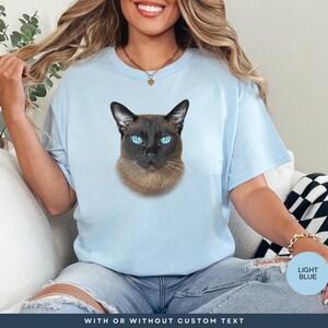 a woman sitting on a couch wearing a t - shirt with a picture of a