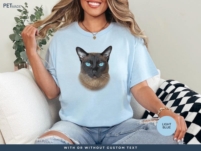 a woman sitting on a couch wearing a t - shirt with a picture of a