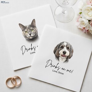 two square cards with illustrations of a cat and a dog, along with the text "Drinks on me! Love, Snow" printed on them.