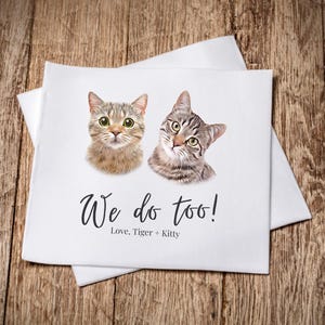 two cats, one gray and one brown, sitting on a wooden surface. The text below the image reads "We do too! Love, Tiger + Kitty".
