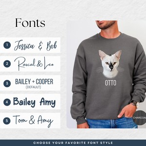 a man wearing a sweatshirt with a picture of a cat on it