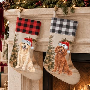 May include: Two Christmas stockings featuring illustrations of dogs wearing Santa hats. The left stocking has a red and black buffalo plaid cuff and a golden retriever named Cooper. The right stocking has a gray and black plaid cuff and a brown dog named Hazel.
