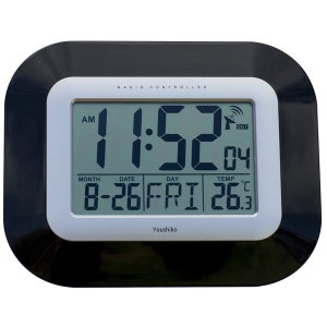 May include: A black and silver digital clock with a radio controlled feature. The clock displays the time, date, day of the week, and temperature. The time is 1:52 AM, the date is 08-26, the day is Friday, and the temperature is 26.3 degrees Celsius. The clock is made by Youshiko.