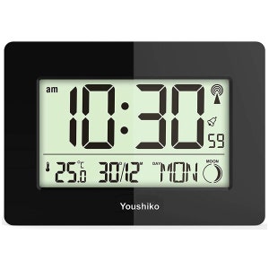 May include: A black digital alarm clock showing 10:30 AM on a green LCD screen, with the date, day, and temperature displayed. The clock also features a moon phase indicator and a wireless signal icon. The brand name "Youshiko" is printed at the bottom.