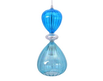 May include: A hanging light fixture with a unique design. The fixture features two blue glass bulbs, one teardrop-shaped and the other bulb-shaped, connected by a decorative clear and white glass element. The glass has a ribbed texture.