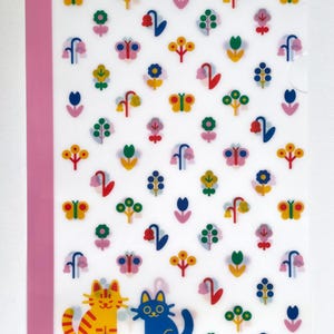 May include: A translucent plastic document folder featuring a repeating pattern of colourful flowers and butterflies. A solid pink vertical strip runs along the left edge. At the bottom, there is an orange striped cat and a solid blue cat.