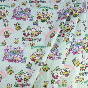 May include: A green fabric with a repeating pattern of cartoon frogs. The frogs are wearing different outfits and holding various items, such as ice cream cones, baseball bats, and musical instruments. The fabric also features the text "KEROPPI" in a stylized font.