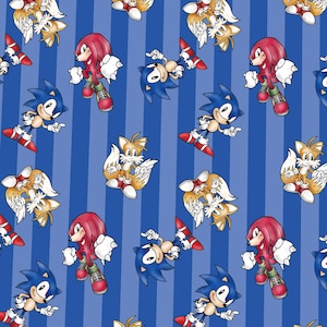 Könnte beinhalten: Ein sich wiederholendes Muster auf einem blauen Hintergrund mit vertikalen Streifen, das die Zeichentrickfiguren Sonic the Hedgehog, Tails und Knuckles the Echidna in verschiedenen Posen zeigt. Die Figuren sind in ihren klassischen Farben Blau, Gelb und Rot dargestellt.