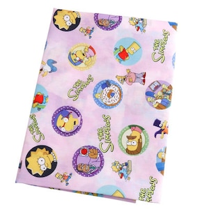 May include: Pink fabric with a repeating pattern of The Simpsons characters. The characters include Homer, Marge, Bart, Lisa, Maggie, and others. The fabric is printed with "The Simpsons" in a white font.