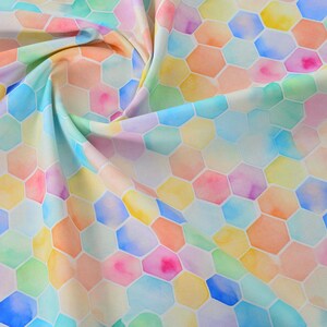 May include: A fabric with a watercolour design featuring a repeating pattern of colourful, irregular hexagons. The fabric has a soft, flowing appearance with hues of blue, pink, yellow, orange, and green.