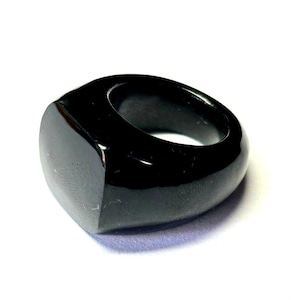 May include: A black signet ring with a square face.