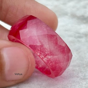 Op de afbeelding: Een roze en witte gefacetteerde ring van hars. De ring is gemaakt van helder hars met een roze swirl en een gefacetteerd ontwerp.