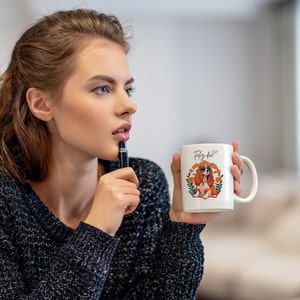 Puede incluir: Juego de tres tazas de cerámica color crema con esmalte moteado. Cada taza presenta un diseño floral pintado a mano en tonos rosa, azul y verde. Las tazas tienen una forma simple y redondeada, con asa.