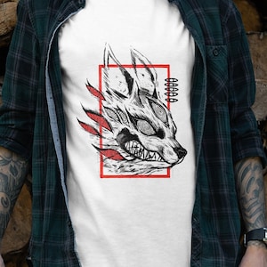 Peut inclure: T-shirt blanc avec une illustration en noir et blanc d'une tête de loup avec des accents rouges. Les yeux du loup brillent et le texte "000000" est sur le côté droit de l'image.