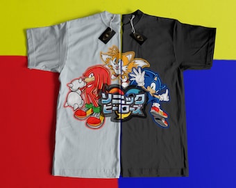 May include: A black and white t-shirt with a split design featuring four characters from the Sonic the Hedgehog video game series. The left side of the shirt features Knuckles the Echidna and Tails the Fox, while the right side features Sonic the Hedgehog and Shadow the Hedgehog. The text "Sonic Heroes" is printed in the center of the shirt.