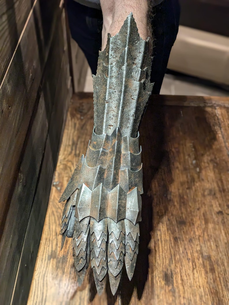 以下が含まれることがあります： 質感のある風化した仕上げの金属製のハンド。ハンドは複数の連動するプレートで構成されており、爪のような外観になっています。