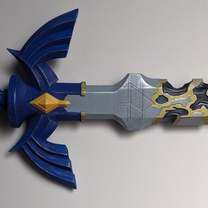 Peut inclure: Une épée bleue et argentée avec une poignée dorée et noire. L'épée a une lame triangulaire avec une pointe pointue et une poignée incurvée. La poignée est décorée d'un motif doré et noir.