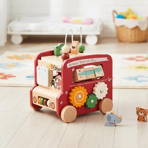 May include: A red wooden toy bus with the text "Animal tourism Bus". The bus has wooden wheels, gears, and animal-themed blocks. Additional wooden animal figures, including an elephant and tiger, are nearby. The toy is designed for children.