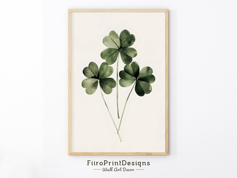 Pode incluir: Uma impress&atilde;o emoldurada de tr&ecirc;s trevos de quatro folhas verdes sobre um fundo branco. A impress&atilde;o &eacute; intitulada "FiitoPrintDesigns - Decora&ccedil;&atilde;o de parede".