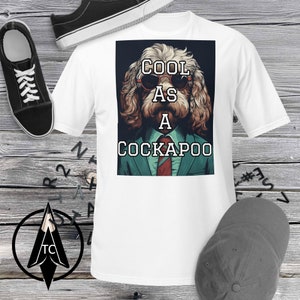 May include: White t-shirt with a graphic of a dog wearing sunglasses and a suit. The text "COOL AS A COCKAPOO" is printed on the graphic.