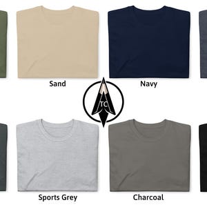 May include: A set of ten folded t-shirts in various colors, including military green, sand, navy, heather navy, dark heather, sports grey, charcoal, and black.