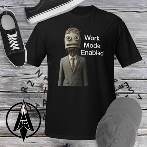 May include: Black t-shirt featuring a graphic of a robot in a suit and tie. The text "Work Mode Enabled" is printed on the shirt.