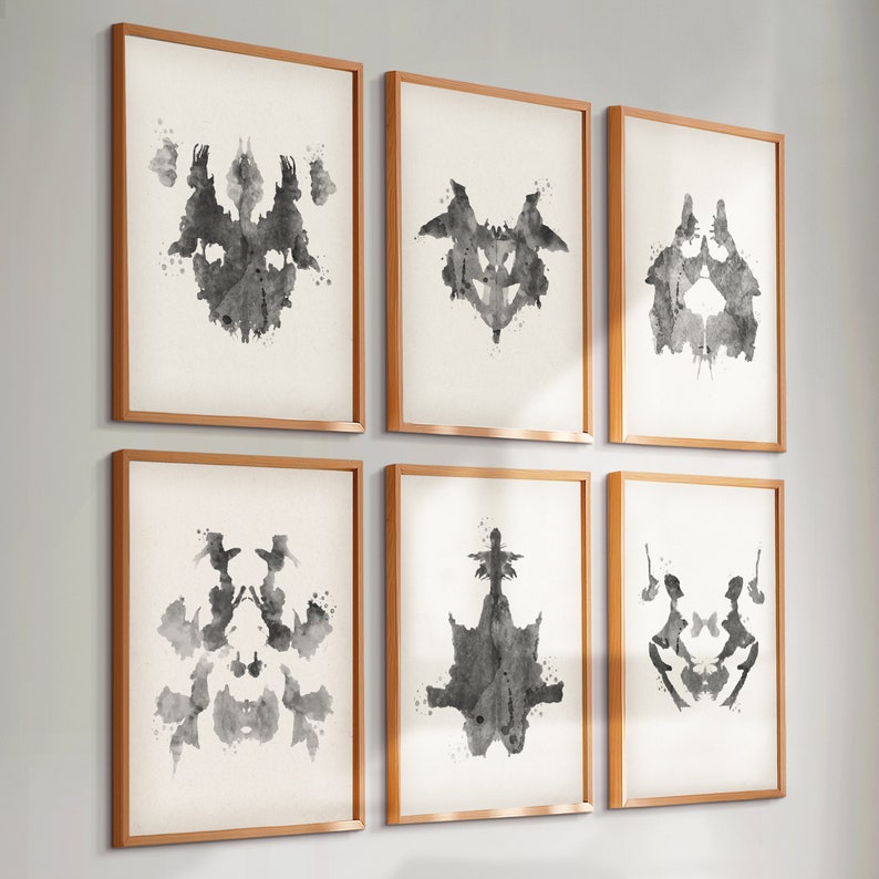 Puede incluir: Seis impresiones de manchas de tinta en blanco y negro enmarcadas, cada una con un dise&ntilde;o abstracto diferente. Los marcos son de madera clara.