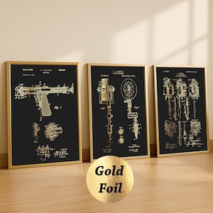 K&ouml;nnte beinhalten: Drei gerahmte Patentdrucke mit goldfarbenen Illustrationen auf schwarzem Hintergrund. Die Drucke befinden sich in goldenen Rahmen. Sie zeigen technische Zeichnungen verschiedener mechanischer Ger&auml;te. Ein goldener Folienkreis mit der Aufschrift "Gold Foil" befindet sich vor den Rahmen.