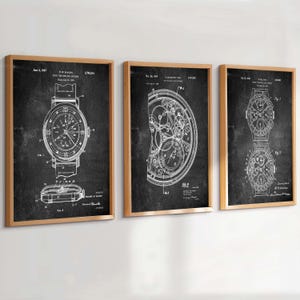 Può includere: Tre stampe incorniciate di brevetti di orologi. Ogni stampa presenta un'illustrazione bianca dettagliata su sfondo nero, che mostra diversi aspetti dei meccanismi degli orologi. Le cornici sono di colore marrone chiaro, aggiungendo un tocco classico all'opera.