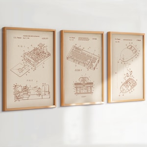 Könnte beinhalten: Drei gerahmte Vintage-Patentdrucke mit einem Diskettenlaufwerk, einer Computertastatur und einer Computermaus. Die Sepia-Drucke haben braune Strichzeichnungen und Text und sind in hellbraunen Holzrahmen gefasst.