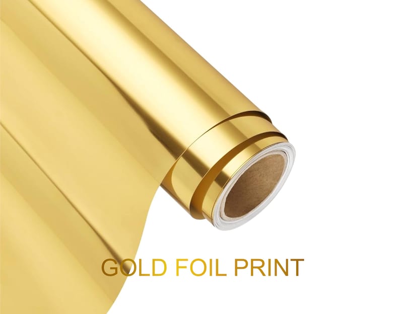 May include: A roll of metallic gold foil material with a smooth, reflective surface. The roll is partially unspooled, revealing a cardboard core. The text GOLD FOIL PRINT is displayed in gold capital letters below the roll of material.