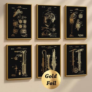 Könnte beinhalten: Sechs gerahmte Patentdrucke mit Goldfoliendesigns auf schwarzem Hintergrund. Die Drucke zeigen detaillierte technische Zeichnungen verschiedener Werkzeuge und Instrumente mit goldenen Rahmen. Die Drucke sind an einer neutralen Wand angeordnet.