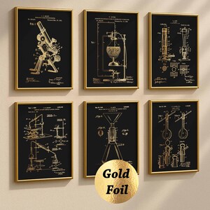 Könnte beinhalten: Ein Set aus sechs gerahmten Wandbildern mit goldenen wissenschaftlichen Patentillustrationen auf schwarzem Hintergrund. Jeder rechteckige Druck zeigt technische Diagramme von Laborgeräten mit Text, eingefasst in dünne goldfarbene Rahmen.
